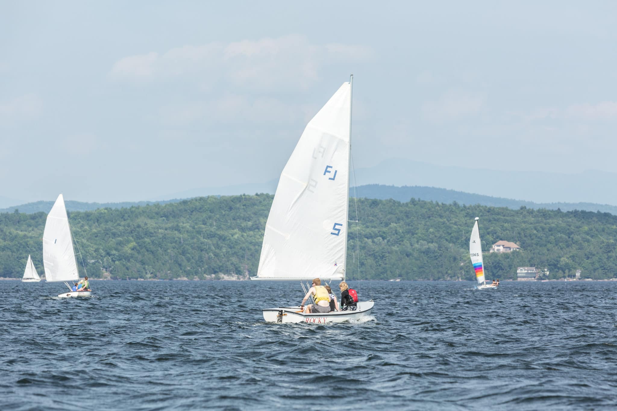 Three sailboats on the waterfront.